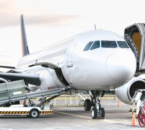 Side view of airplane at airport terminal gate - Emergency travel concept with international flights canceled due to worlwide virus outbreak - Bright desaturated filter